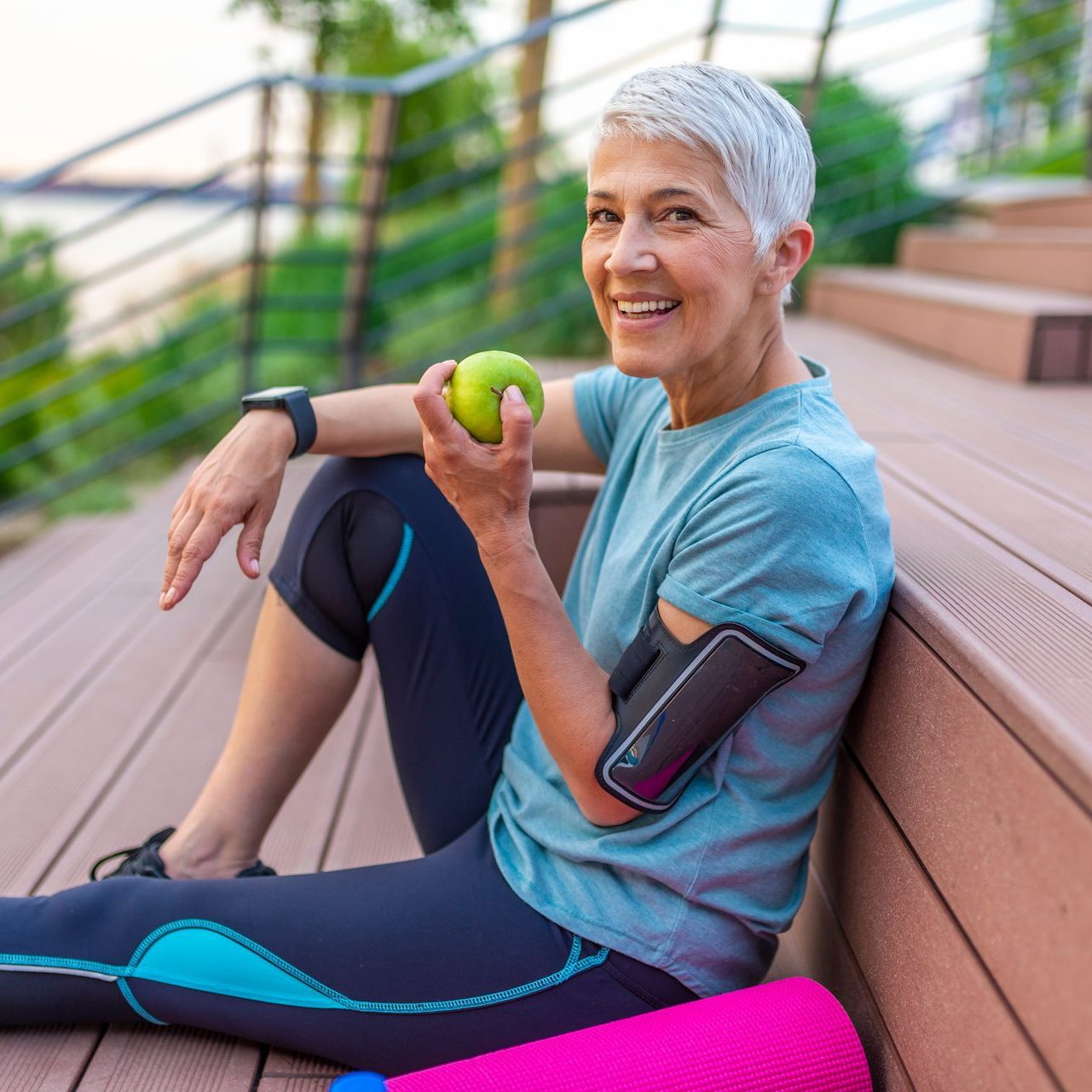 Sporty mature woman eating an apple